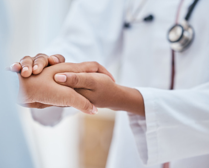 Doctor holding a patient’s hand.